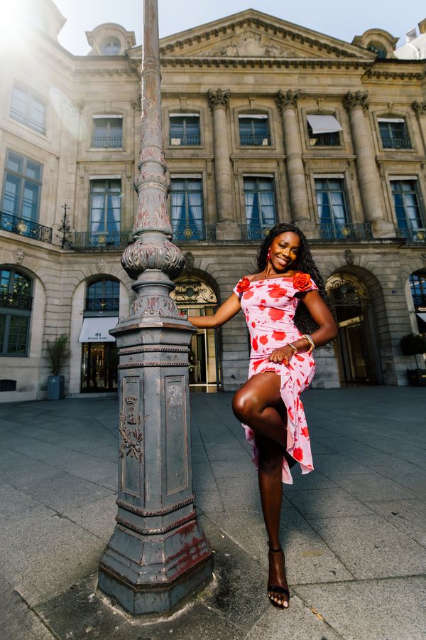 Portrait of a woman in red floral off-shoulder dress, Place Vendôme, Paris at golden hour