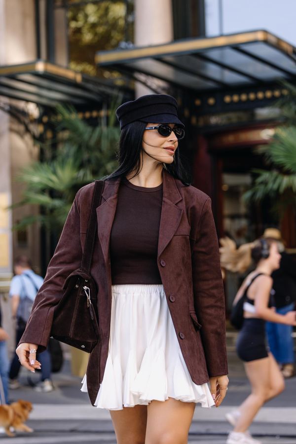Street style: brown blazer, black cap, black top, white pleated skirt, shoulder bag, Paris