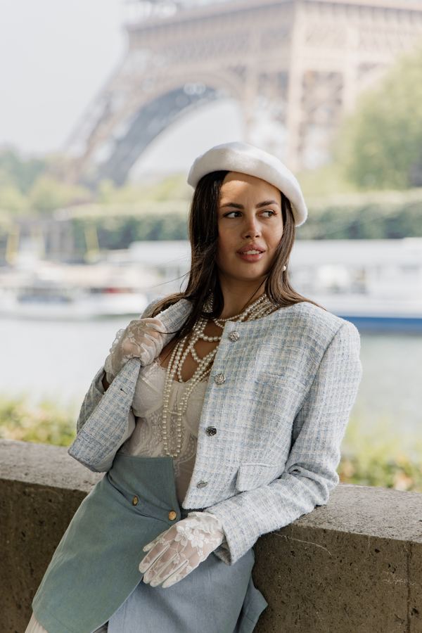 Portrait of a woman in blue tweed jacket, pearls, lace gloves, bridge over the Seine, Paris