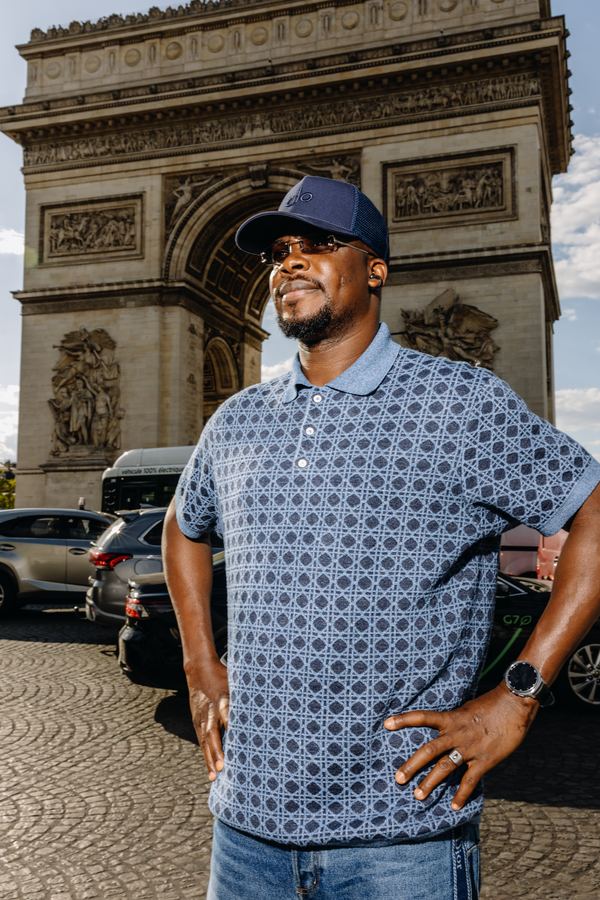 Portrait of a man in blue patterned knit polo, navy cap, Paris
