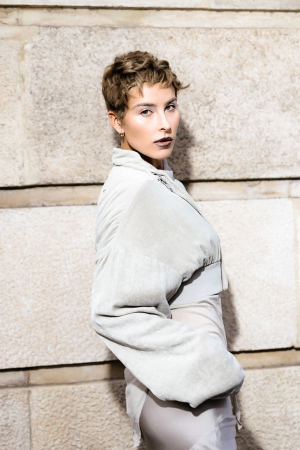 Portrait of a woman in silver cropped puffer jacket, silver satin skirt, Paris
