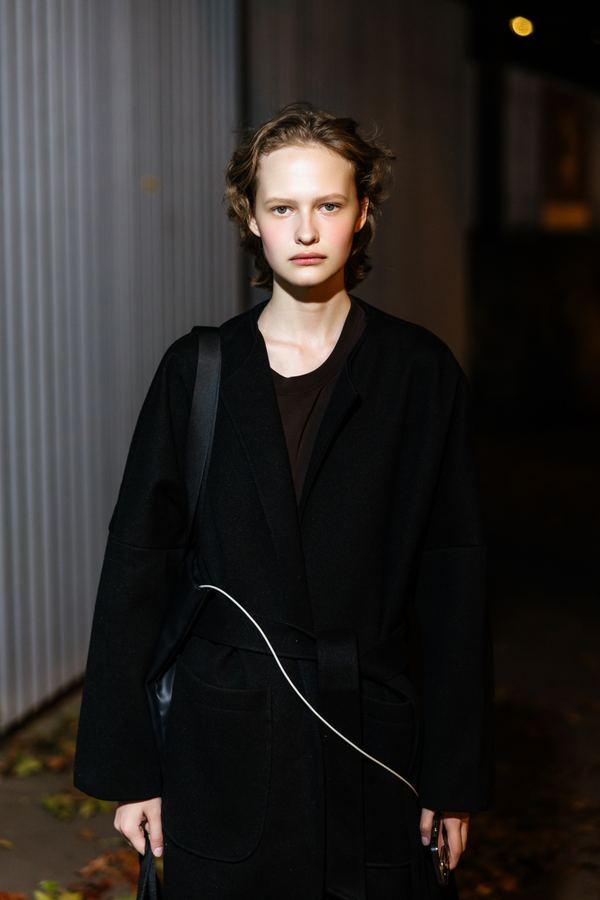 Street style at Paris Fashion Week: black long coat, dark top, Paris at night