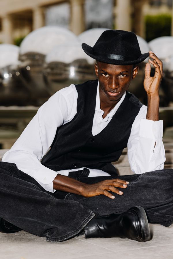 Portrait of a man in black vest, white shirt, black hat, dark trousers, chrome sphere fountain, Paris
