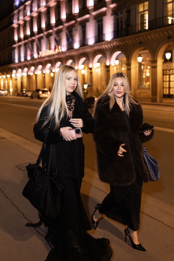 Street style: black long coat, black sheer skirt, black heels, Paris at night