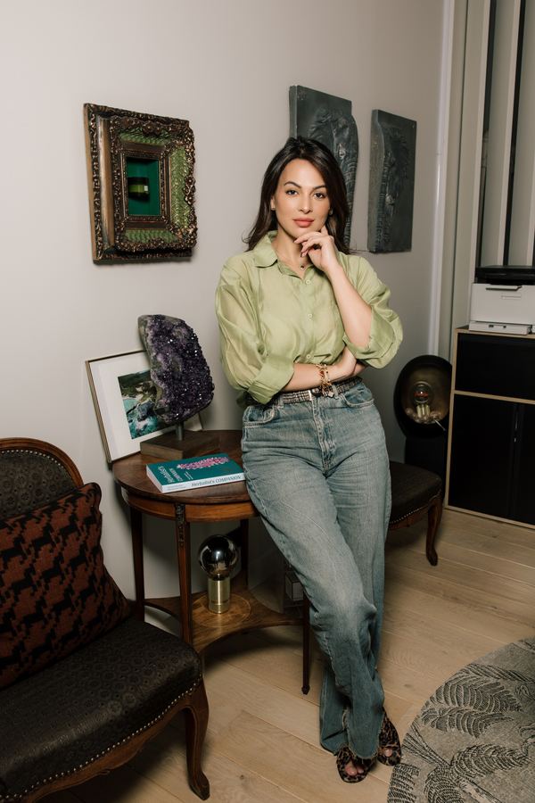 Portrait of a woman in sage satin shirt, jeans, apartment interior, Paris