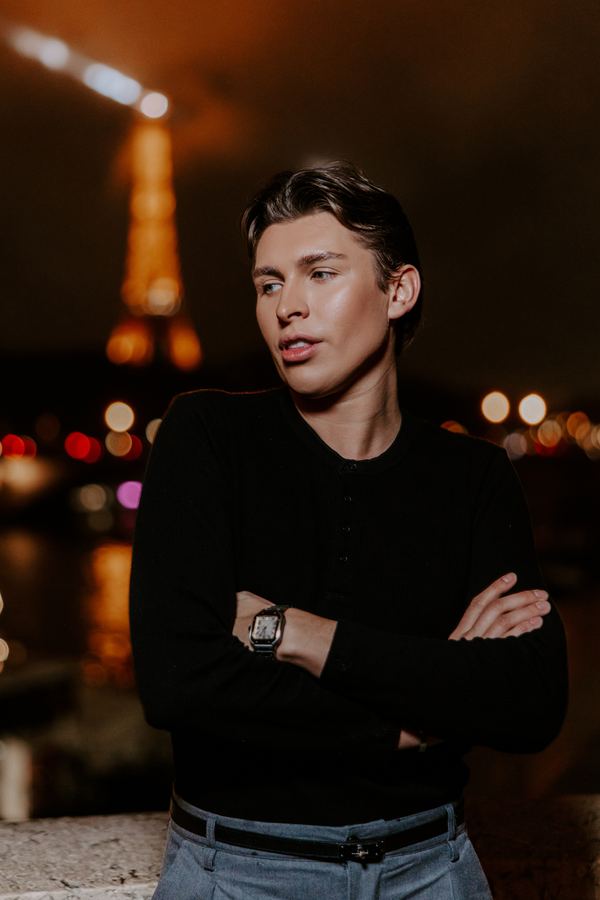 Portrait of a man in black henley, grey trousers, Eiffel Tower, Paris at night