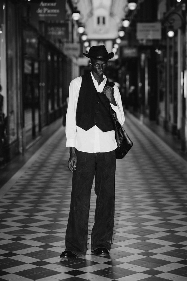 Street style: black vest, white shirt, dark wide trousers, hat, tote, covered passage, Paris