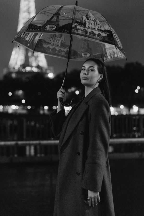 Portrait of a woman in grey long coat, Eiffel Tower, Paris at night