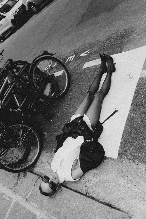 Street style: black leather jacket, white shirt, tie, black shorts, black heels, Paris